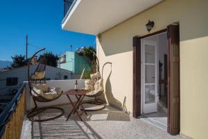 patio con mesa y sillas en el balcón en Billy's House en Samos