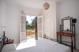 - une chambre avec un lit et un miroir dans l'établissement Billy's House, à Samos