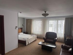 une chambre d'hôtel avec un lit et une chaise dans l'établissement Hotel Bliss, à Bucarest