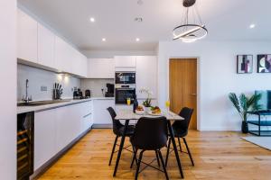 a kitchen and dining room with a table and chairs at Axium Suite- Modern 2 bed in Birmingham City Centre- Perfect for Business, Family and Leisure Stays in Birmingham
