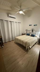 a bedroom with a bed and a ceiling fan at Las Ranitas in Parque del Plata