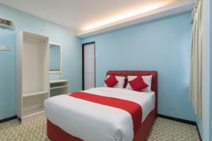 a bedroom with a large bed with red pillows at Star Hotel in Port Dickson