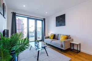 uma sala de estar com um sofá e uma mesa de vidro em Axium Suite- Modern 2 bed in Birmingham City Centre- Perfect for Business, Family and Leisure Stays em Birmingham