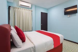 a bedroom with a bed with red and white pillows at Star Hotel in Port Dickson