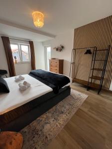 Un dormitorio con una cama grande y una lámpara de araña. en UNiQE I 90qm I Bergblick I 3 Balkone I seenah, en Prien am Chiemsee