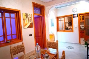comedor con mesa, sillas y puerta en Oasis appart sérénité, en Marrakech