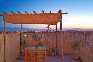 une structure en bois avec des oiseaux assis au-dessus d'une clôture dans l'établissement Oasis appart sérénité, à Marrakech