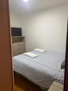 een slaapkamer met een bed en een dressoir met 2 handdoeken bij victoria in Porvenir