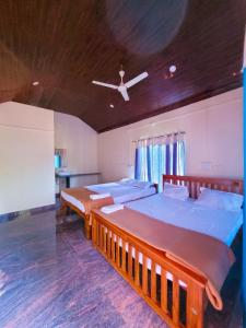 a bedroom with two beds and a ceiling at The Stone Cabin Cottage in Gokarna