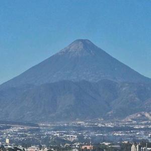 Una montaña con una ciudad delante de ella en VISTALAGO APARTMENTS en Guatemala