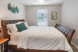 1 dormitorio con cama y ventana en Cozy Two Bedroom Home Minutes from Downtown! en Houston