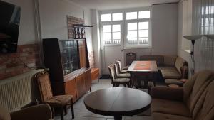 a living room with a tv and a table and chairs at FEWO Begegnung mit Lounge in Bautzen