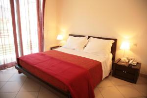 a bedroom with a large bed with a red blanket at Residence San Paolo in Lido di Savio
