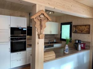 cocina con armarios blancos y encimera de madera en Chalet in Hohentauern - Chalet Ana, en Hohentauern