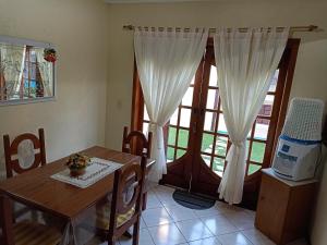 a dining room with a table and a window at Casa Azul em Búzios in Búzios