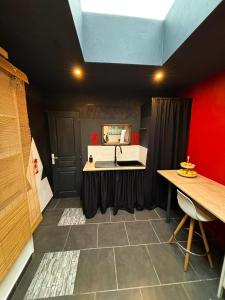 La salle de bains est pourvue d'un lavabo et d'un mur rouge. dans l'établissement Apartment Cuba Zen Actitud, à Mouscron