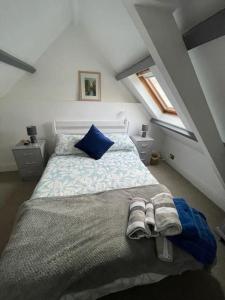 ein Schlafzimmer mit einem Bett mit Handtüchern darauf in der Unterkunft Traditional Stone cottage in heart of the village in Llangwm