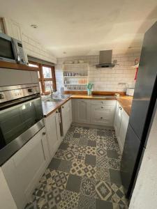 a kitchen with a tiled floor in a kitchen at Traditional Stone cottage in heart of the village in Llangwm
