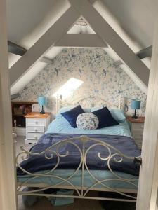 ein Schlafzimmer mit einem Bett im Dachgeschoss in der Unterkunft Traditional Stone cottage in heart of the village in Llangwm