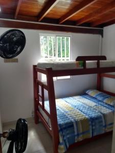 a bedroom with two bunk beds and a window at Cabañas Mayarena in San Antero