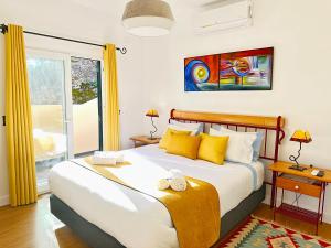 1 dormitorio con 1 cama grande con almohadas amarillas en Porto Moniz Villa en Porto Moniz