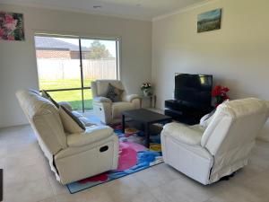 a living room with three chairs and a tv at Paradise pavilion hide away in Cranbourne