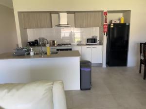 a kitchen with a counter and a black refrigerator at Paradise pavilion hide away in Cranbourne