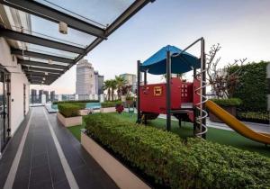 um parque infantil com um escorrega no telhado em Steps to Vincom/Casino/D1/pool/gym/Netflix/3Beds em Ho Chi Minh