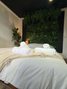 - un lit avec des serviettes et un mur vert dans l'établissement La maison d'Aline, à Arras