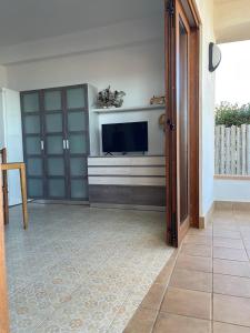 een woonkamer met een flatscreen-tv en een deur bij Apartament Tere in Oliva