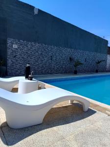 a white bench sitting next to a swimming pool at Residencia Dos Soles 2.0 in Resistencia