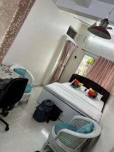 a bedroom with a bed and chairs and a window at Varsha's Villa A Luxurious Stay. in Nagpur