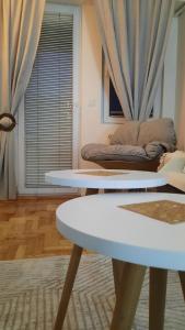 uma sala de estar com duas mesas e um sofá em MI-JO em Skopje