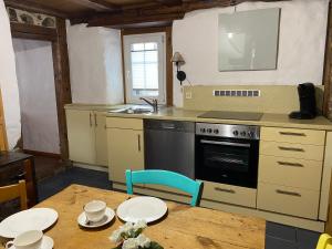 a kitchen with a stove and a table with plates on it at Schwarzwald - Ferienhaus in Tannheim in Villingen-Schwenningen