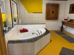 a bathroom with a large white tub with a red towel at Schwarzwald - Ferienhaus in Tannheim in Villingen-Schwenningen