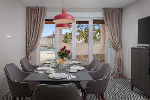 une salle à manger avec une table et des chaises noires dans l'établissement Vacation house Mater, à Žrnovnica