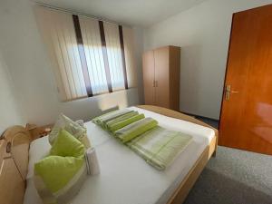 Glamočani的住宿－Bijeli Cvijet，一间卧室配有一张带绿色枕头的床。