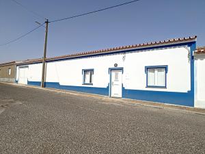 un edificio blanco y azul al lado de una calle en Casa Refugio Do Campo, en Reguengos de Monsaraz