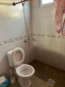 a bathroom with a white toilet and a window at Apartamento paysandu in Paysandú