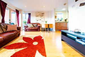- un salon avec un canapé et un tapis de fleurs rouge dans l'établissement Superhost 1 bedroom flat 15 mins to center,zone 2, à Londres