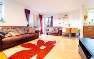 - un salon avec un canapé brun et un tapis rouge dans l'établissement Superhost 1 bedroom flat 15 mins to center,zone 2, à Londres