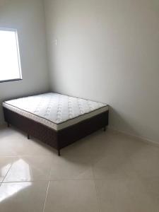 a bed sitting in a corner of a room at Casa Conceição da Barra temporada e Carnaval in Conceição da Barra