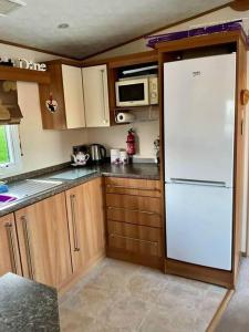 uma cozinha com um frigorífico branco e armários de madeira em 10 min walk to South Devon beach em Paignton
