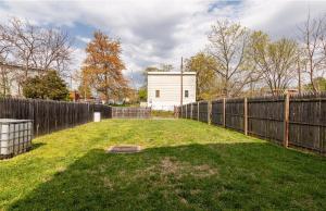 a yard with a fence and a white house at Luxurious and Cozy Room in Washington DC in Washington