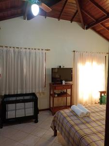 a bedroom with a bed and a tv and a window at Casa Azul em Búzios in Búzios +31 photos