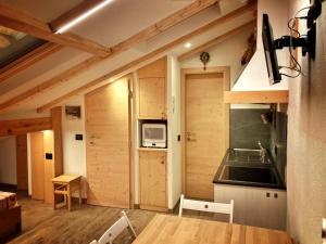 a room with a kitchen with a microwave and a sink at Ad Alba di Canazei una finestra sulla Marmolada in Alba di Canazei
