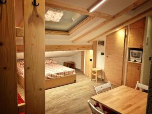 a bedroom with a bed and a table in a room at Ad Alba di Canazei una finestra sulla Marmolada in Alba di Canazei