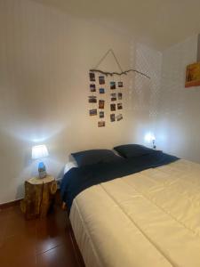 1 dormitorio con 1 cama y 1 mesa con lámpara en Appartamento Homemade, en Biella