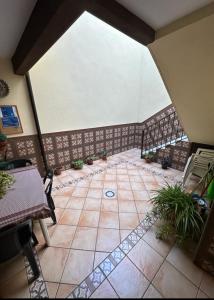 an attic room with a tiled floor with plants at Casa Mari in Sanlúcar de Barrameda