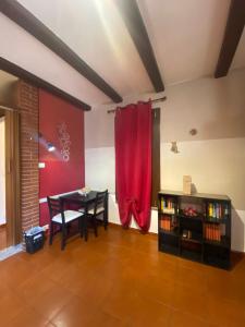 une salle à manger avec un rideau rouge et une table dans l'établissement Appartamento Homemade, à Biella